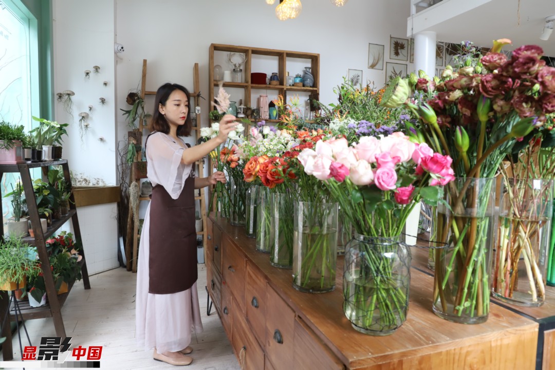 王黎媛是一名河南姑娘，在昆明念完大學(xué)后，就再也舍不下春城的藍(lán)天陽(yáng)光、青山碧水，更舍不下這里的四時(shí)繁花，于是就干脆留了下來(lái)，成了一名媒體人。2017年的時(shí)候又毅然辭去工作，創(chuàng)業(yè)開(kāi)起了花店，成了都市里的一名“花房姑娘”。圖為王黎媛在自己的花店中整理鮮花。新華網(wǎng) 周亞平/攝 念新洪/文